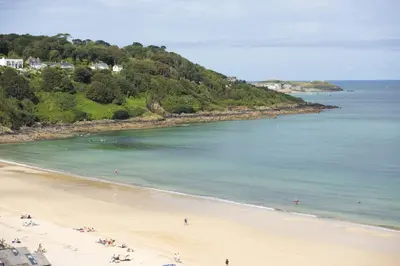 a beach with a group of people in the water at Emerald - Stunning Views - Free Parking and WiFi - Coffee Machine in Carbis Bay