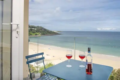 two glasses of wine on a table with a view of the beach at Emerald - Stunning Views - Free Parking and WiFi - Coffee Machine in Carbis Bay