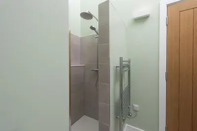 a shower with a glass door in a bathroom at Redshank-Pets Allowed-River View-Cinema Room-Free Parking & WiFi in Looe