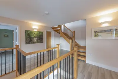 a staircase in a home with wooden railings at Redshank-Pets Allowed-River View-Cinema Room-Free Parking & WiFi in Looe