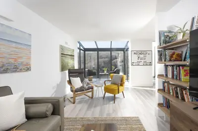a living room with a couch and a table and chairs at Redshank-Pets Allowed-River View-Cinema Room-Free Parking & WiFi in Looe