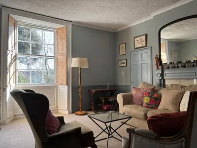 a living room with a couch and chairs and a window at Church View, Helston Old Town in Helston