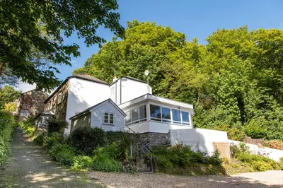 a white house on a hill with trees at Atlantic House En-Suite Bedrooms 5 mins to Beach and Shops in St. Agnes