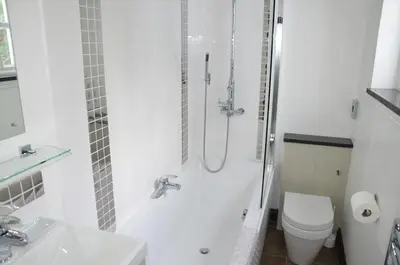 a white bathroom with a shower and a toilet at Atlantic House En-Suite Bedrooms 5 mins to Beach and Shops in St. Agnes