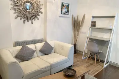 a living room with a white couch and a table at Atlantic House En-Suite Bedrooms 5 mins to Beach and Shops in St. Agnes