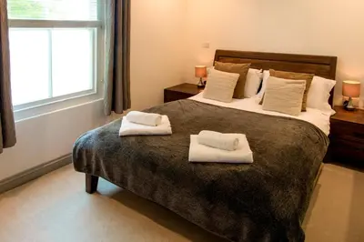 a bedroom with a large bed with two towels on it at Atlantic House En-Suite Bedrooms 5 mins to Beach and Shops in St. Agnes