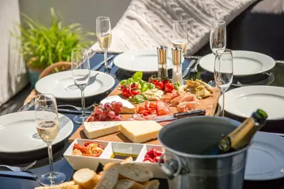 a table with plates of food and glasses of wine at Atlantic House En-Suite Bedrooms 5 mins to Beach and Shops in St. Agnes