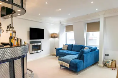 a living room with a blue couch and a tv at 90A Tower Road in Newquay