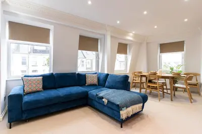 a living room with a blue couch and a table at 90A Tower Road in Newquay