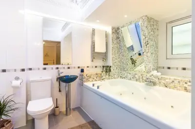 a bathroom with a tub and a toilet and a sink at 90A Tower Road in Newquay