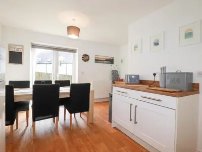 a kitchen and dining room with a table and chairs at Poldam in St Austell