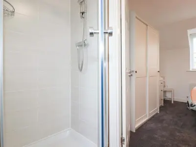 a shower with a glass door in a bathroom at Poldam in St Austell