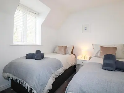 a bedroom with two beds and a window at Poldam in St Austell