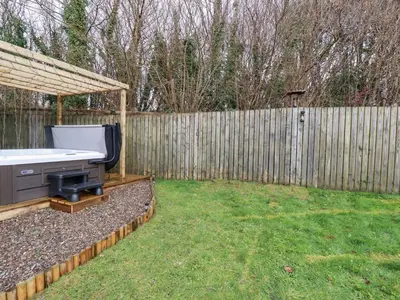 a backyard with a grill and a fence at Poldam in St Austell