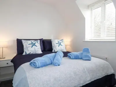 a bed with blue pillows on top of it at Poldam in St Austell