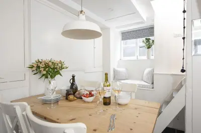 a dining room with a wooden table with wine glasses at Walters on The Digey - 100m to beach - pets allowed in St Ives