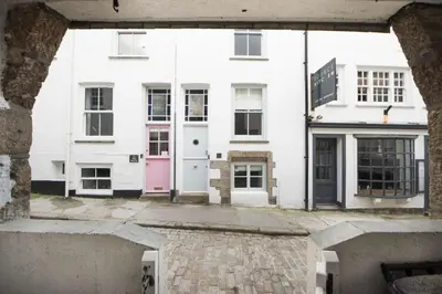 a group of white houses with a pink door at Walters on The Digey - 100m to beach - pets allowed in St Ives