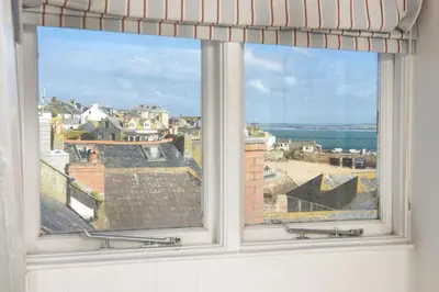 a window with a view of a city and the ocean at Walters on The Digey - 100m to beach - pets allowed in St Ives