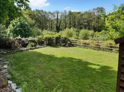 a backyard with a fence and a grass yard at Cottage - Sleeps 2 - River Lynher walks & fishing in Linkinhorne
