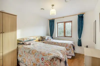 a bedroom with two beds and a window at 3 Bed in Polruan oc-l35010 in Fowey