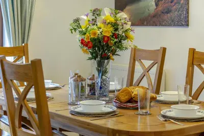 a wooden table with a vase of flowers on it at 3 Bed in Polruan oc-l35010 in Fowey