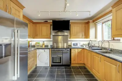 a kitchen with wooden cabinets and white appliances at 3 Bed in Polruan oc-l35010 in Fowey