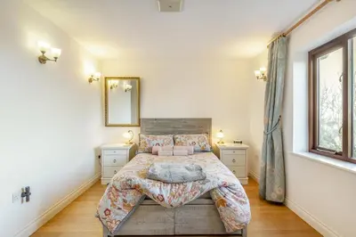 a bedroom with a bed and a mirror on the wall at 3 Bed in Polruan oc-l35010 in Fowey