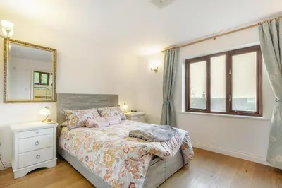 a bedroom with a bed with a mirror and a window at 3 Bed in Polruan oc-l35010 in Fowey