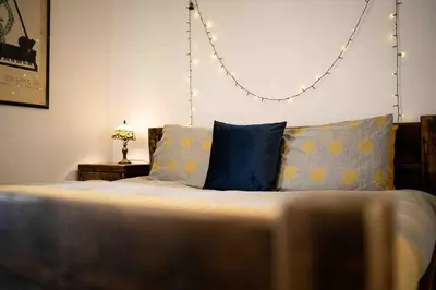 a bedroom with a bed with blue and yellow pillows at Cosy Flat in the centre of St Ives in St Ives
