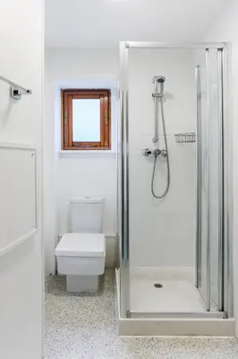 a bathroom with a shower with a toilet and a window at Cosy Flat in the centre of St Ives in St Ives