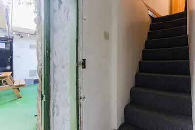 a staircase leading up to a room with green floors at Cosy Flat in the centre of St Ives in St Ives