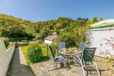 a patio with a table and chairs in a garden at 2 Bed in St. Agnes oc-h27472 in St. Agnes