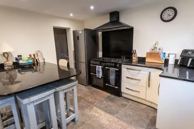 a kitchen with a stove and a refrigerator at Steppes Lodge in Looe