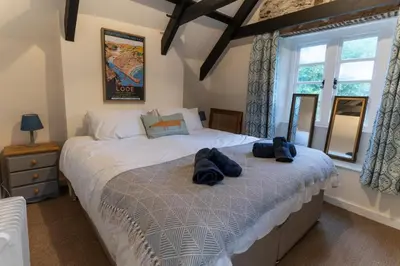 a bedroom with two beds with towels on it at Steppes Lodge in Looe