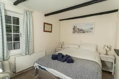 a bedroom with a bed with blue towels on it at Steppes Lodge in Looe
