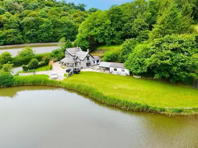 an aerial view of a house next to a river at Steppes Lodge in Looe