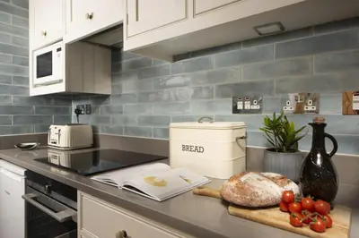 a kitchen counter with a loaf of bread on a cutting board at 1 The Cottages - Family friendly, Parking, Woodburner in Penzance