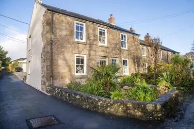 an old stone building with plants in front of it at 1 The Cottages - Family friendly, Parking, Woodburner in Penzance