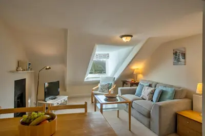 a living room with a couch and a tv at Finest Retreats - Smugglers Loft at Mixtow Creek in Lanteglos