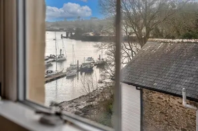 a window view of a river with boats in the water at Finest Retreats - Bosuns Loft at Mixtow Creek in Lanteglos