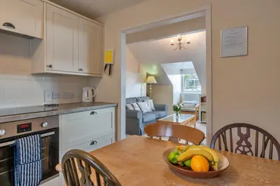 a kitchen with a table with a bowl of fruit on it at Finest Retreats - Bosuns Loft at Mixtow Creek in Lanteglos