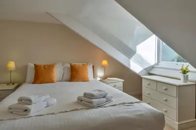 a bedroom with a bed with towels on it at Finest Retreats - Bosuns Loft at Mixtow Creek in Lanteglos