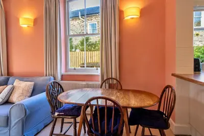 a living room with a table and chairs and a couch at Finest Retreats - Captains Cottage at Mixtow Creek in Lanteglos