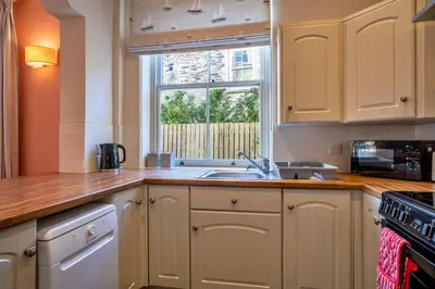 a kitchen with a sink and a window at Finest Retreats - Captains Cottage at Mixtow Creek in Lanteglos