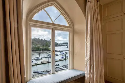 an arched window with a view of a marina at Finest Retreats - Kits House at Mixtow Creek in Lanteglos