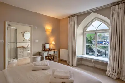 a bedroom with a large bed and a window at Finest Retreats - Kits House at Mixtow Creek in Lanteglos