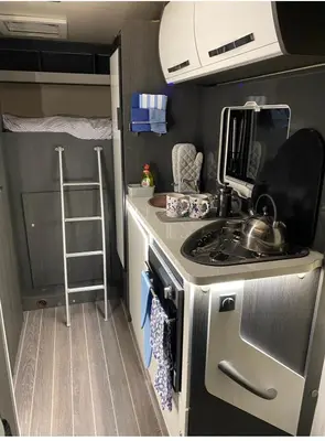 a kitchen with a stove and a sink in an rv at Raffy The Motorhome in St Merryn