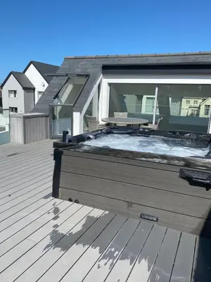 a wooden deck with a bench on top of a house at Detached 4 Bed House with large gardens and Hot Tub in St Merryn