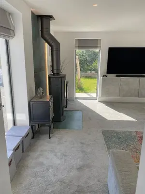 a living room with a fireplace and a flat screen tv at Detached 4 Bed House with large gardens and Hot Tub in St Merryn