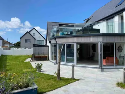an extension of a house with glass doors at Detached 4 Bed House with large gardens and Hot Tub in St Merryn